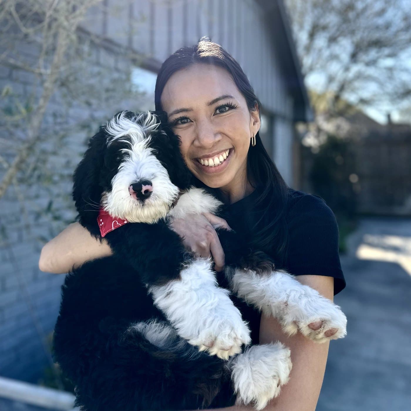 Andrea Le, ADHD coach, smiling and holding her dog
